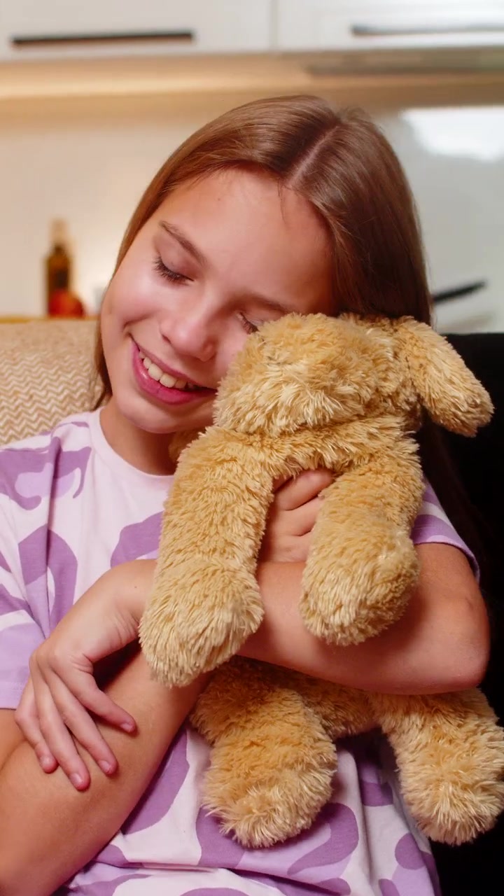 Ragazza adolescente che tiene un peluche a forma di cane, lo abbraccia forte, con un sorriso calmo, trasmettendo un'atmosfera dolce, tenera e infantile.