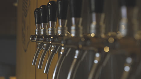 shiny chrome beer taps ready to fill up some pints, depth of field, slow motion