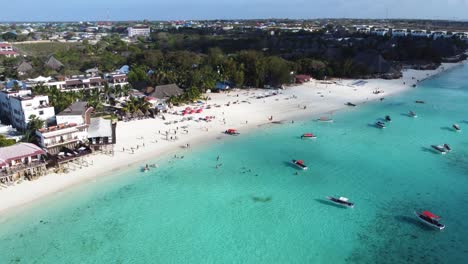 a stunning aerial view of nungwi beach and nungwi town with a lot of water and beach activities on the ocean including many boats
