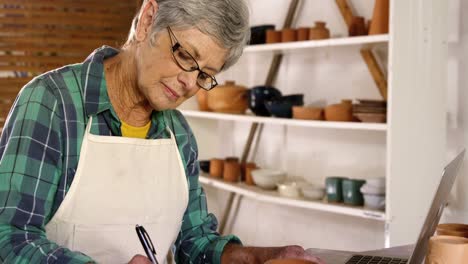 female potter writing on a book