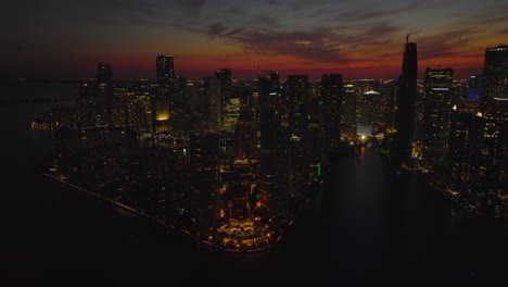 Aerial-panoramic-footage-of-building-on-waterfront.-Illuminated-streets-and-lighted-windows-in-modern-high-rise-apartment-buildings-at-night.-Miami,-USA