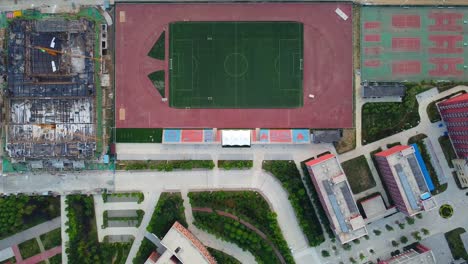 Vista-Aérea-Ascendente-Del-Campo-De-Fútbol-En-La-Universidad-Jiaotong-De-Beijing,-Weihai