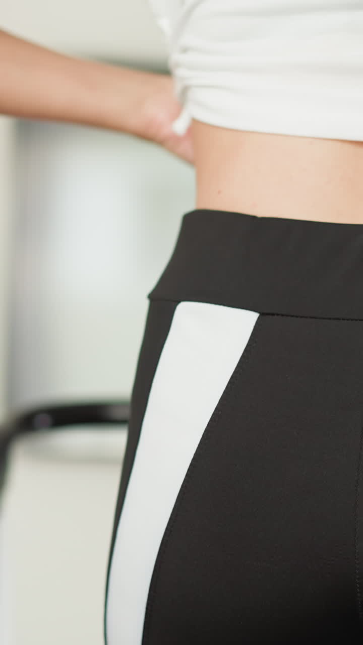 mujer ajusta la parte superior para entrenar en el hogar de cerca. mujer delgada con ropa activa cómoda ejercicios en cinta de correr en gimnasio doméstico cámara lenta. estilo de vida activo