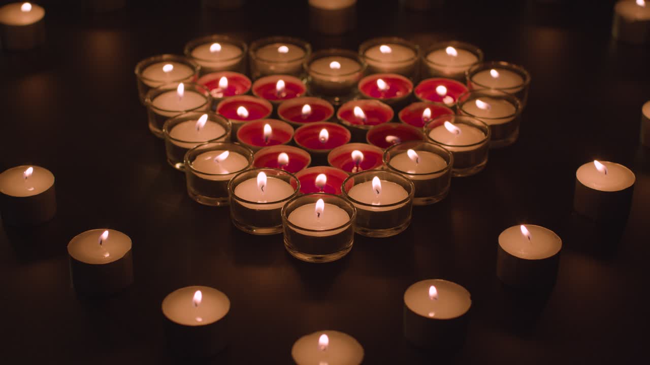 velas rojas y blancas románticas en forma de corazón sobre fondo negro