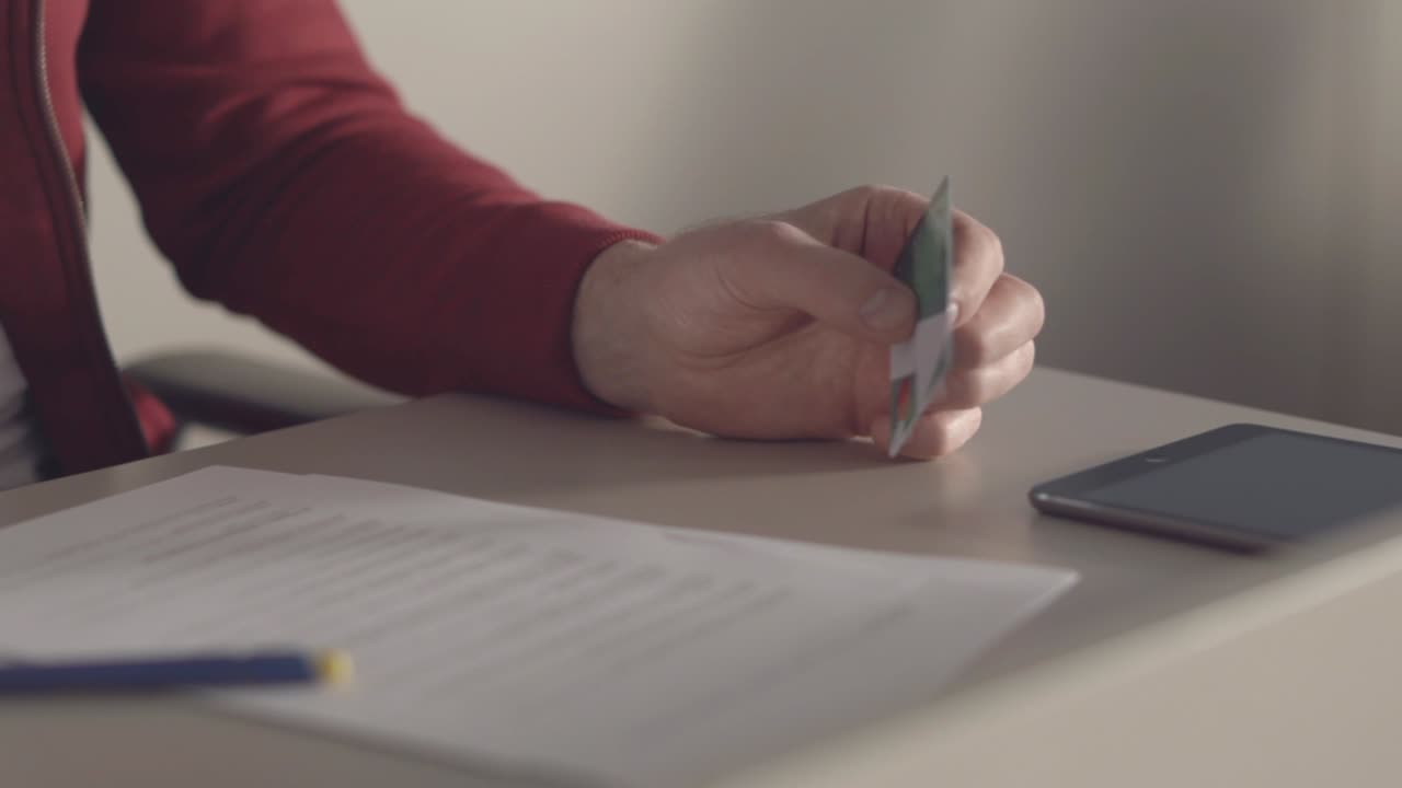 Man holding a credit card and documents