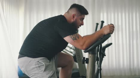 Joven-Atleta-Trabajador-Entrena-En-Bicicleta-Estática-Giratoria