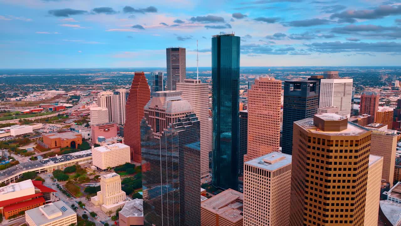 Houston, EE. UU., 24 de noviembre de 2025: Rascacielos de Houston al atardecer con un cielo naranja vibrante. Toma aérea de cerca de altos edificios de oficinas y rascacielos en Houston durante un colorido atardecer.