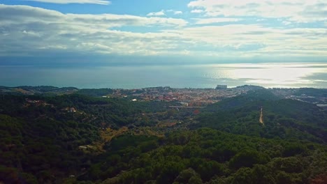 Relajante-Vista-De-Un-Pueblo-Costero-En-España-Al-Mediodía-Con-Hermosos-Bosques-Justo-Al-Lado-Del-Mar