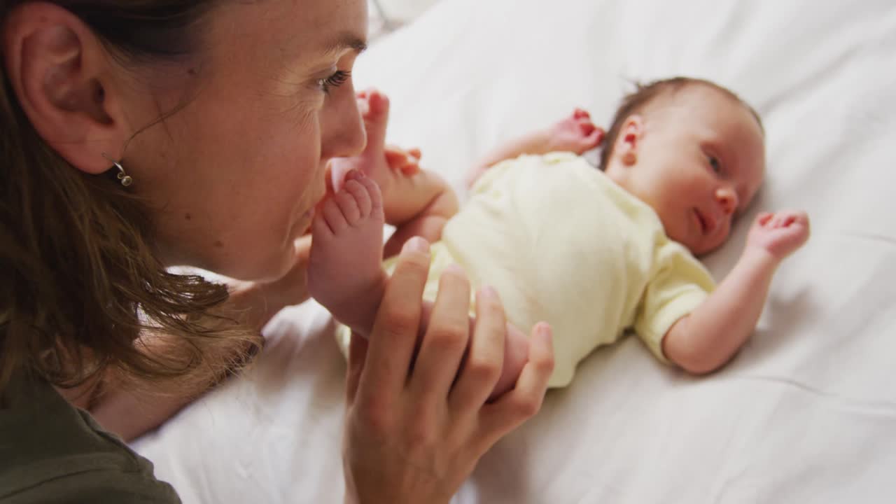 행복 한 백인 어머니 가 신생아 의 발 을 키스 하는 영상