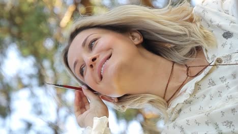 woman artist paints a picture in a summer park in sunlight hobby to paint pictures