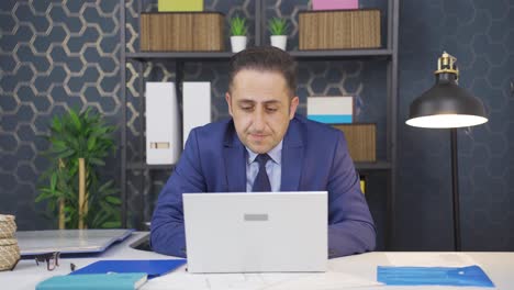 un hombre de negocios estresado usando una computadora portátil.