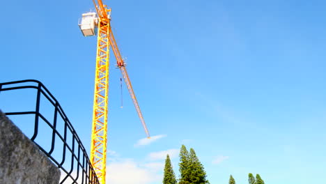 massive yellow construction crane at work on building site of new development