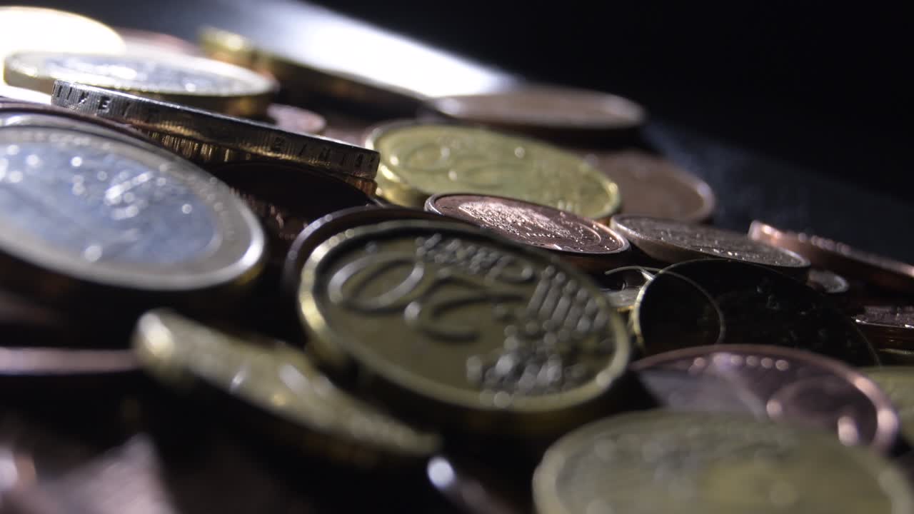 montaña de diferentes monedas de euro girando con fondo negro