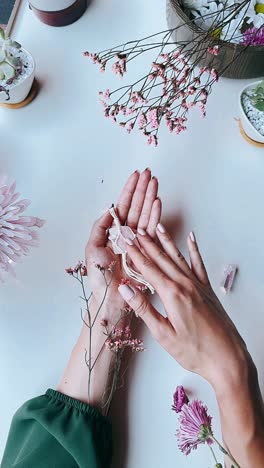 hands holding flowers, crystals, and lace