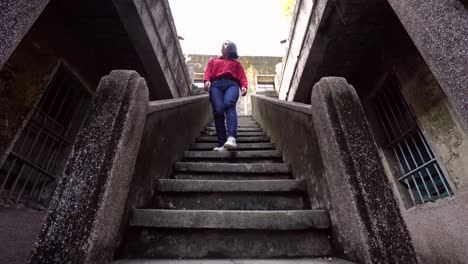 Cheerful-woman-walking-down-steps-of-old-house