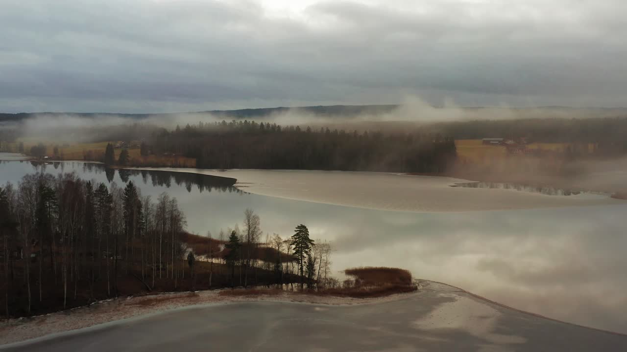Flying over a small island in a partially frozen lake in Sweden