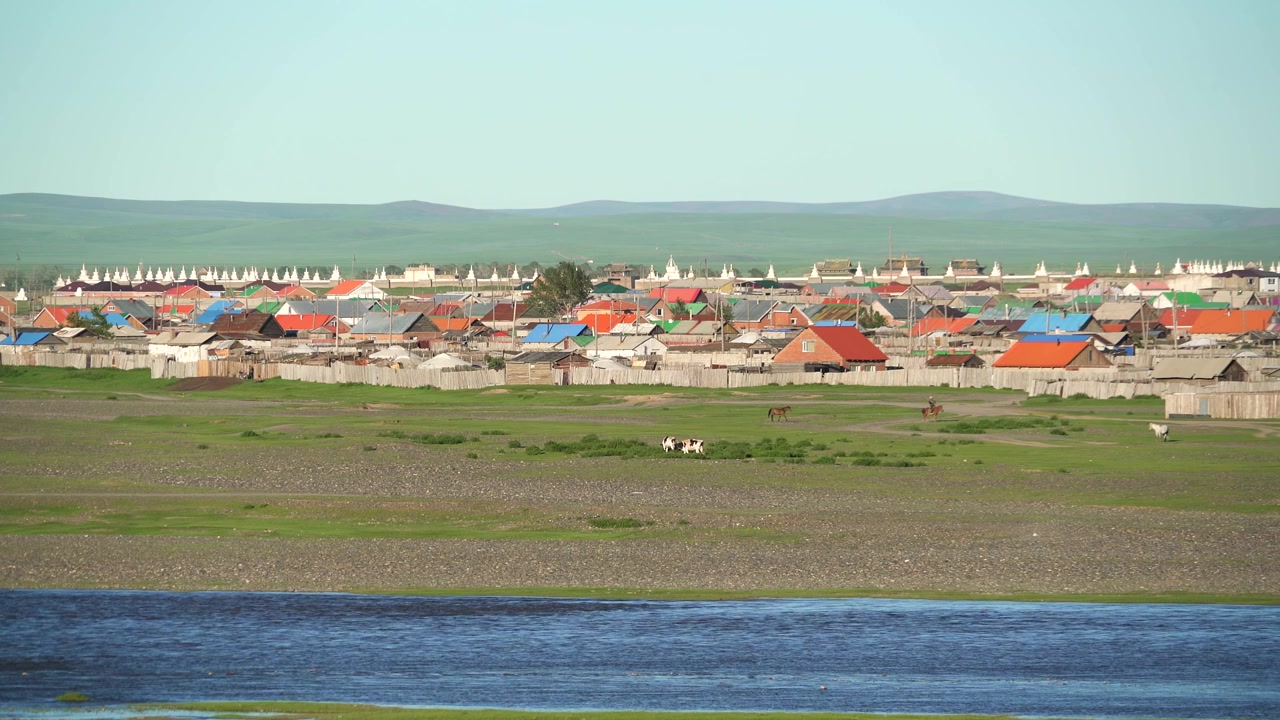 Pieni kylä värikkäine taloineen joen lähellä Mongolian arolla