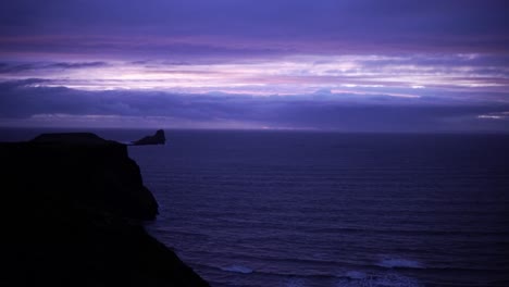 man walks near the sea with stunning purple sunset