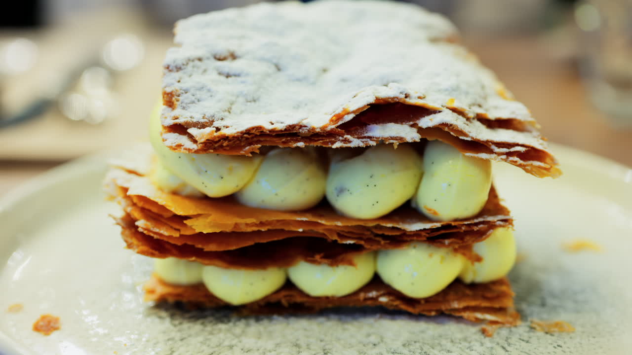 Close up of a piece of Pistachio Mille-Feuille on a green plate at a restaurant