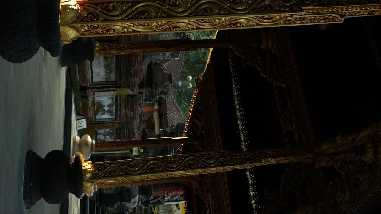 toma en cámara lenta de un edificio del templo en bali en indonesia con columnas doradas y vista del jardín