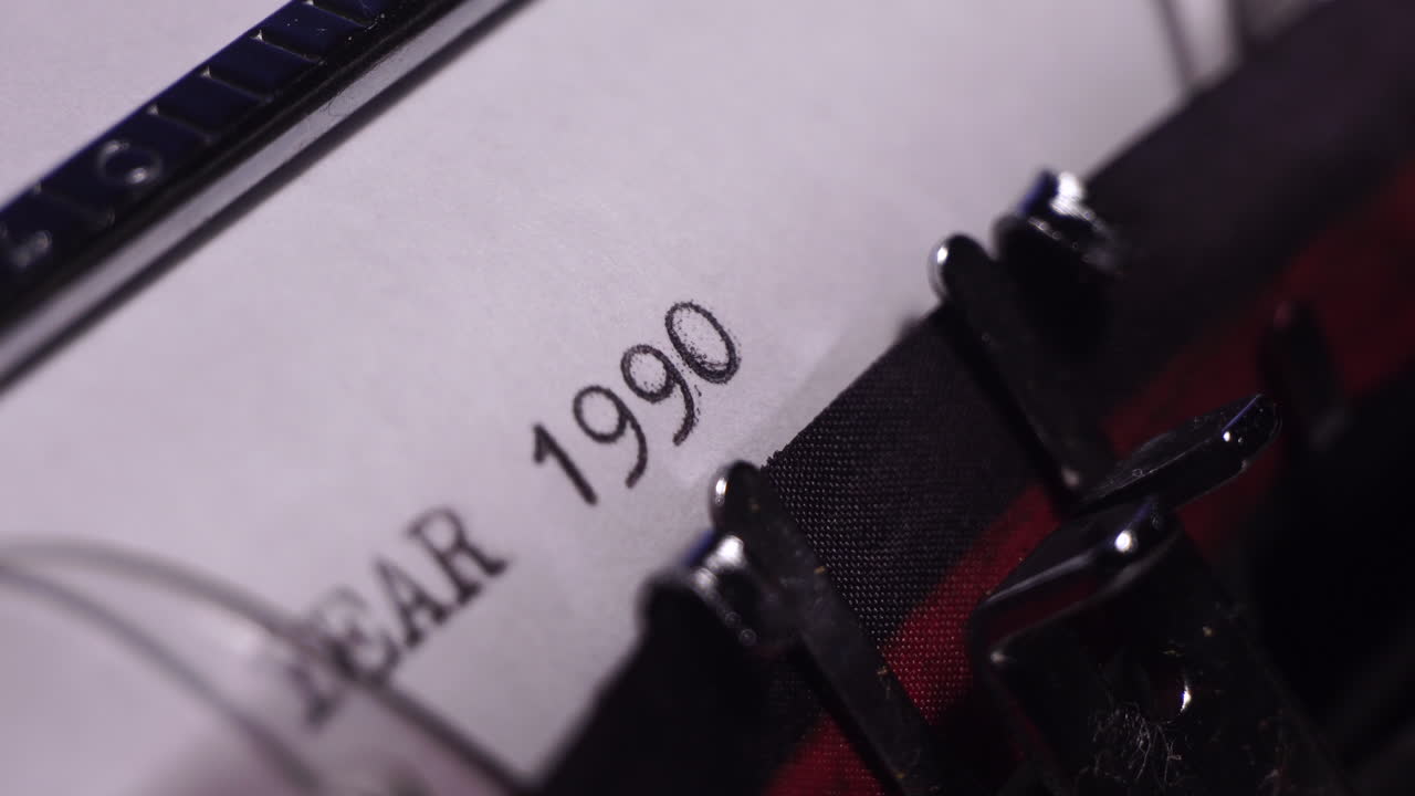 año 1990, escribiendo en papel blanco en una máquina de escribir de época, de cerca