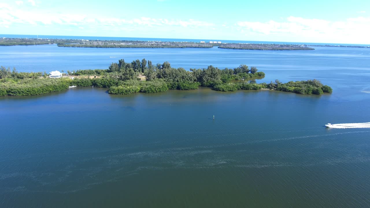 vista aérea de 4k del río indio en melbourne, florida, con lancha rápida entrando en escena