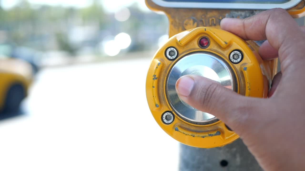 persona presionando un botón de cruce de peatones