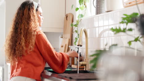 woman washing hands in a kitchen