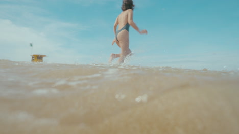 woman running in the water at the beach