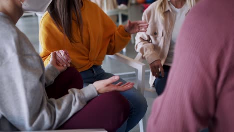 grupo de personas en una sesión de terapia, los miembros se toman de la mano.