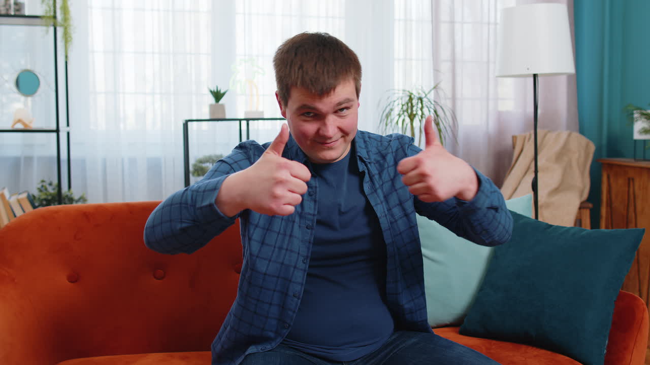 흥분 된 백인 남성 은 카메라 를 승인 으로 바라보며 엄지손가락 을 표시 하는 것 처럼 만족 한 피드백 을 나타니다