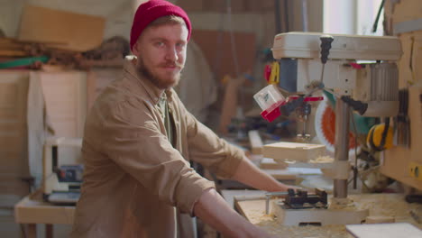 portrait of cheerful woodworker in carpentry workshop
