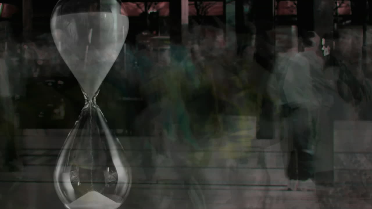 People walking fast with hourglass in the foreground