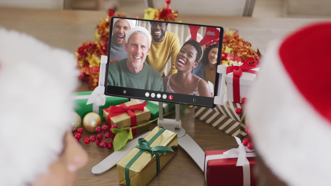 pareja diversa teniendo videoconferencia de navidad con personas diversas