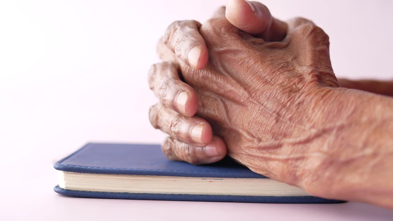Senior women holding a bible in his hands and praying
