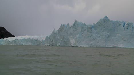 pov from a boat traveling along the edge of a glacier 1