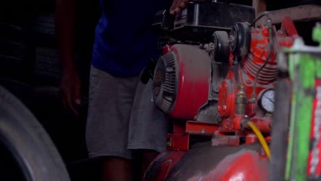 Slow-motion---A-man-starting-air-compressor-belt-driven-machine-on-workshop