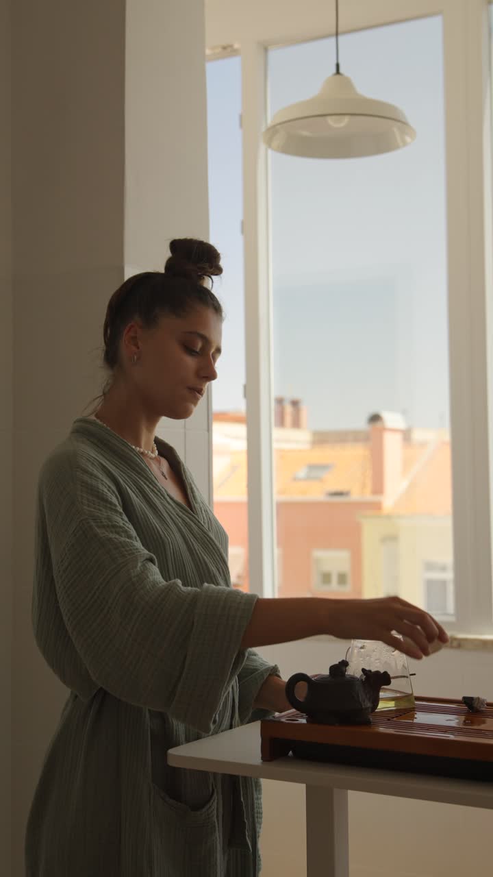 Woman performing a tea ceremony by the window