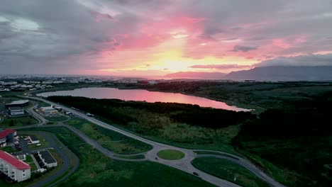 idyllic view of sunset over reykjavik suburbs in south iceland - aerial pullback