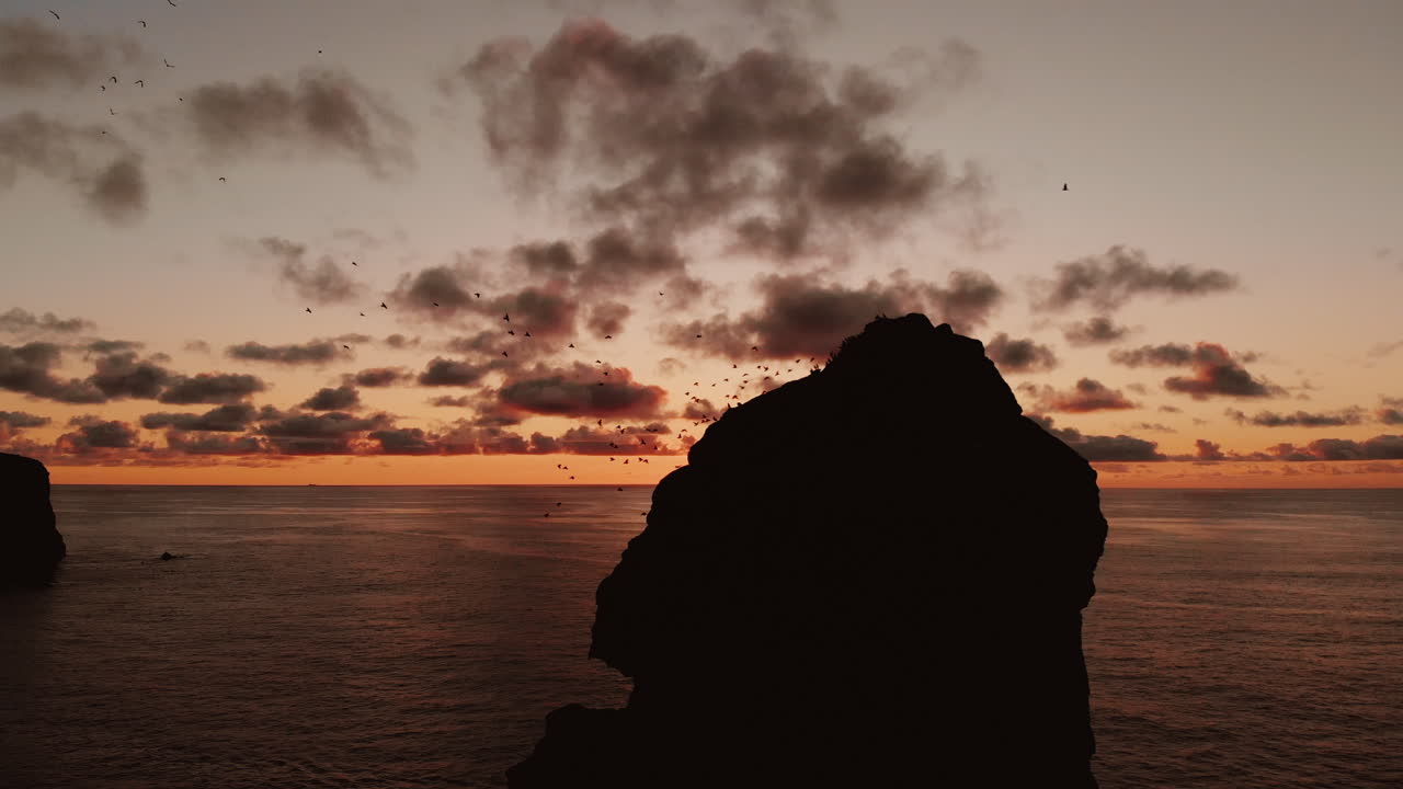 Sunset over a rocky outcrop with seabirds