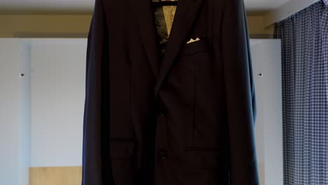 a groom's blue-black suit jacket, with gold-colored interior