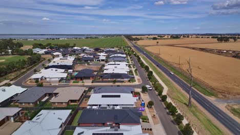 En-Lo-Alto,-Un-Pequeño-Parque-Residencial-Y-Casas-Nuevas-Con-La-Autopista-Midland-Y-Campos-Agrícolas-A-Un-Lado.