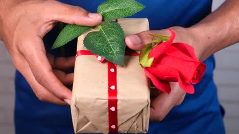 person holding gift with rose