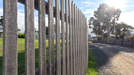 sunlit path beside a wooden fence