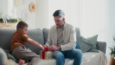 young boy helps his dad with christmas preparations