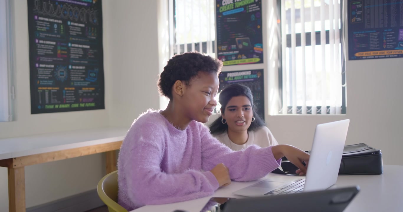 Diverse teens working at code lab, camera shifting causing right pair moving closer, typing laptop