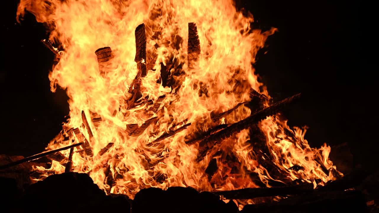 밤에는 자연의 검은색 배경에서 느린 동작으로 큰 불꽃이 불타고 있습니다.