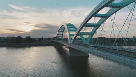 modern bridge over river at sunset