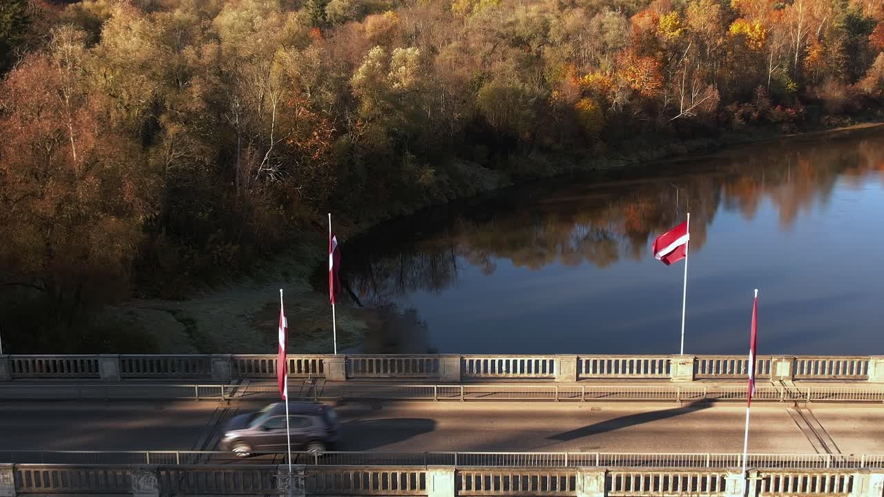 Ponte a Sigulda in autunno con veicoli di passaggio e alberi nelle vicinanze