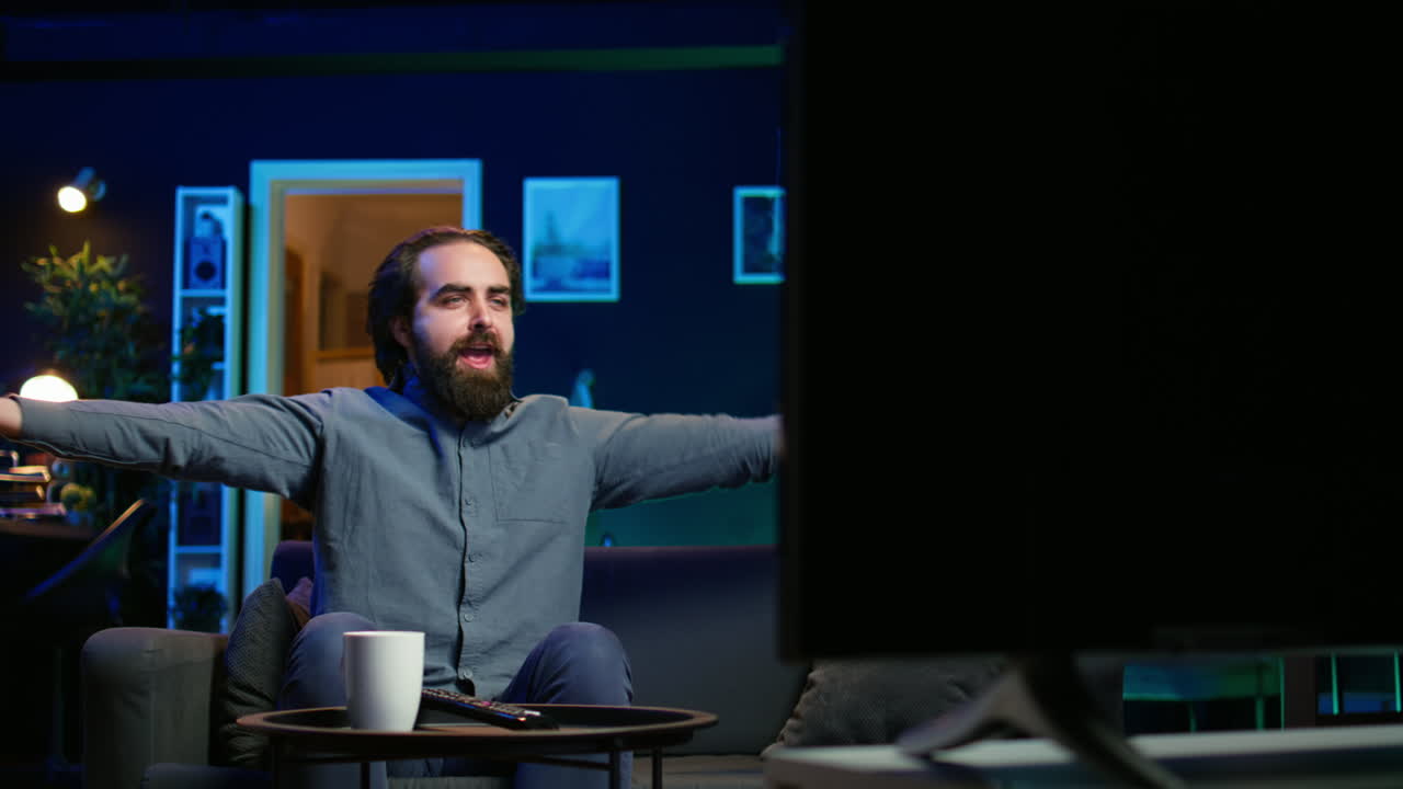 Excited man at home enjoying football competition, clapping hands